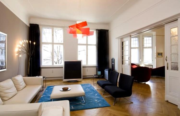 studio apartment design ideas blue carpet black sofas red lantern chandelier palm standing lamp 1